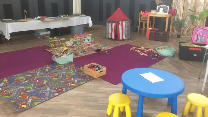 Espace jeux intérieur pour enfants avec ateliers et jouets pendant l’événement.