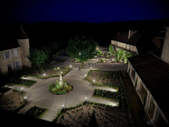 Les jardins du château illuminé à la tombée de la nuit à L’Écrin du Monastère, à Montferrand-le-Château près de Besançon.