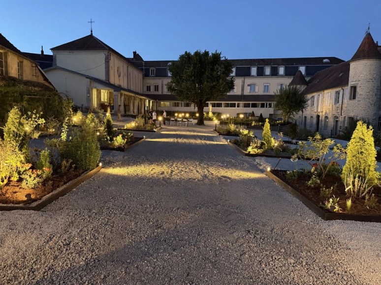 Espace extérieur paysager et illuminé face au couvent de L’Écrin du Monastère, à Montferrand-le-Château.