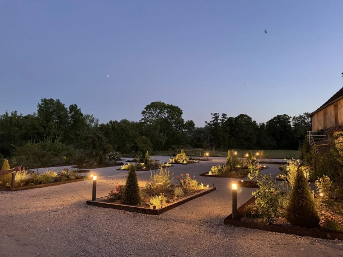 Espace extérieur illuminé en soirée, idéal pour cocktails et réceptions à L’Écrin du Monastère, dans le Doubs.