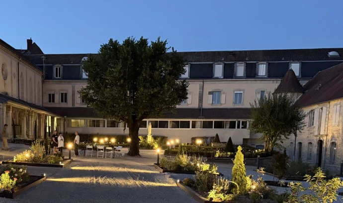 Vue du couvent de L’Écrin du Monastère et de ses jardins illuminés en soirée, à Montferrand-le-Château.