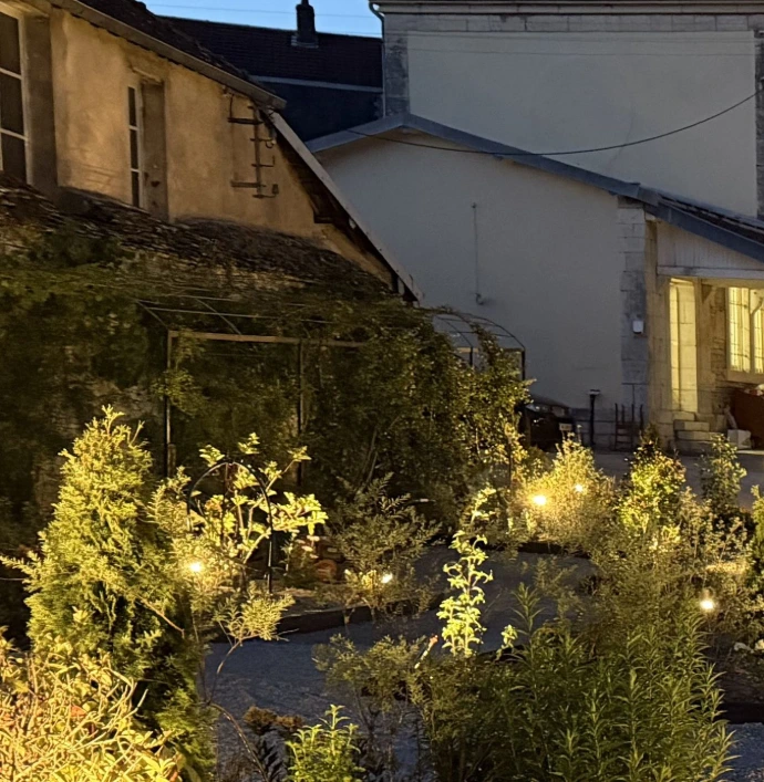 La Longère de L’Écrin du Monastère, autre option d’hébergement, bordée d’un espace extérieur paysager et illuminé en soirée.
